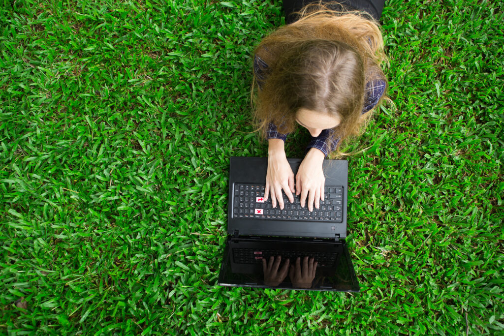 joven trabajando en equipo portatil en la hierba 2 4