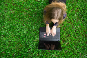 joven trabajando en equipo portatil en la hierba 2 4