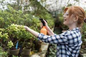 mujer pelirroja cuidando sus plantas en invernadero min 6